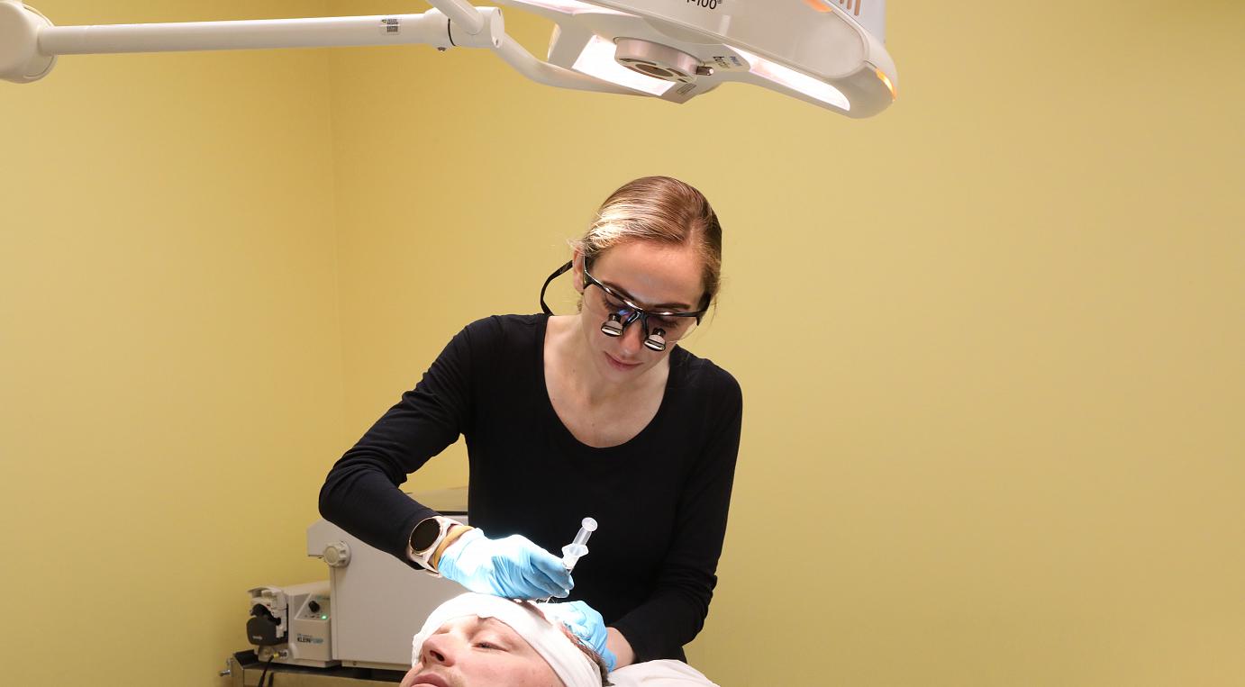 Dr. Marissa Milchak performin hair transplant surgery